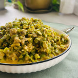 A bowl of Malayan Gising Gising, a Filipino dish made with seafood and vegetables, served on a white plate on top of a green napkin.