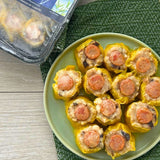 A plate of cooked Chicken & Sausage Siomai, with the packaging visible in the background.