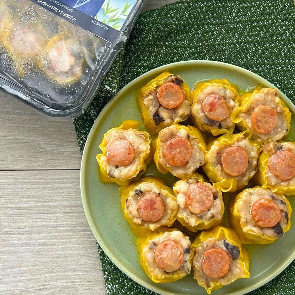 A plate of cooked Chicken & Sausage Siomai, with the packaging visible in the background.
